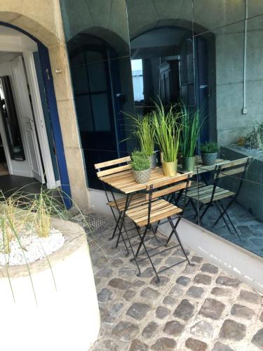 une table et des chaises avec des plantes en pot sur une terrasse dans l'établissement Au cœur du VIEUX-LILLE : Charmant appartement, à Lille