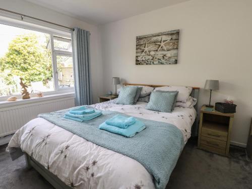 a bedroom with a bed with two towels on it at Benllech Bay Cottage in Benllech