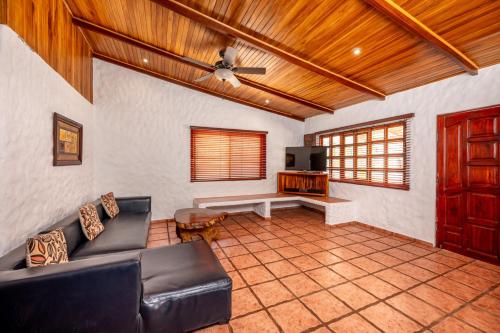 a living room with a couch and a tv at BP Surf Hotel in Playa Grande