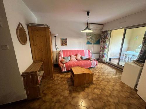 un salon avec un canapé rose et une table dans l'établissement Résidence Alisier - T3 dans le domaine de la Coudoulière proche de la mer MAE-8961, à Six-Fours-les-Plages