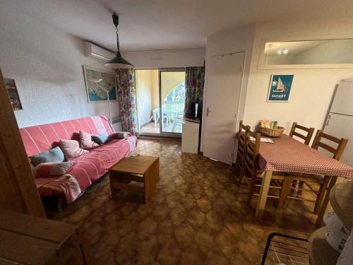 un salon avec un canapé rose et une table dans l'établissement Résidence Alisier - T3 dans le domaine de la Coudoulière proche de la mer MAE-8961, à Six-Fours-les-Plages
