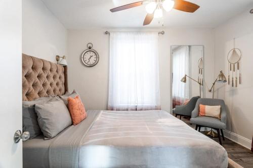 a bedroom with a large bed and a clock on the wall at Spacious&Gracious- 5BR Fam-Friendly near I95&Shops in Fairfield