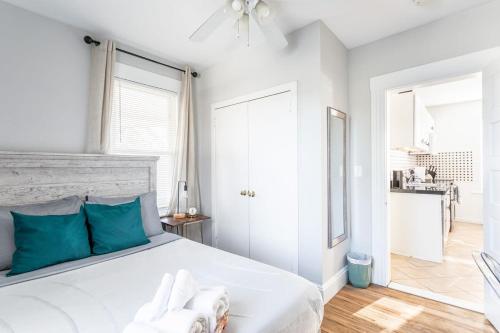 a white bedroom with a large bed with blue pillows at Spacious&Gracious- 5BR Fam-Friendly near I95&Shops in Fairfield