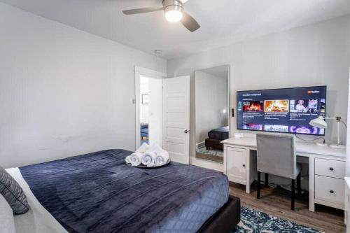 a bedroom with a bed and a desk and a television at Spacious&Gracious- 5BR Fam-Friendly near I95&Shops in Fairfield