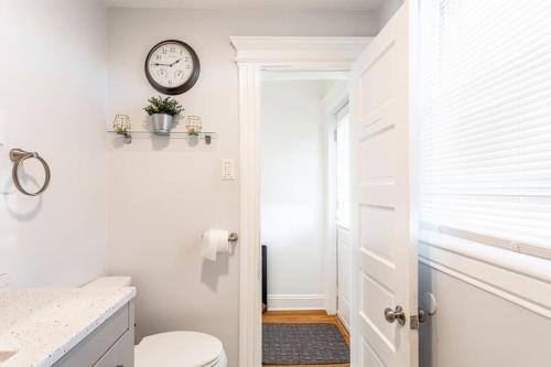 a bathroom with a toilet and a clock on the wall at Spacious&Gracious- 5BR Fam-Friendly near I95&Shops in Fairfield