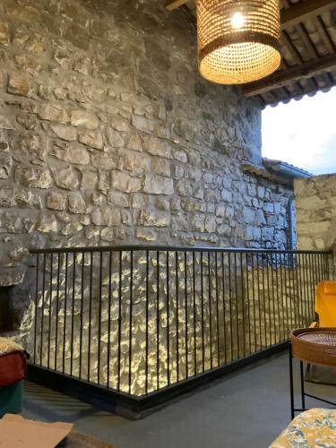 une pièce avec un mur en pierre et une clôture en fer forgé dans l'établissement La terrasse suspendue, à Saint Alban Auriolles