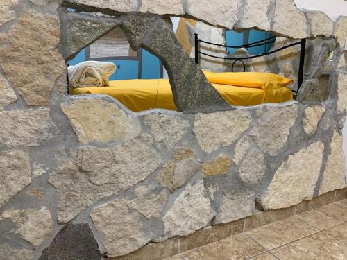 a stone wall with a bed in a room at Villa Isabella in Marina di Grosseto