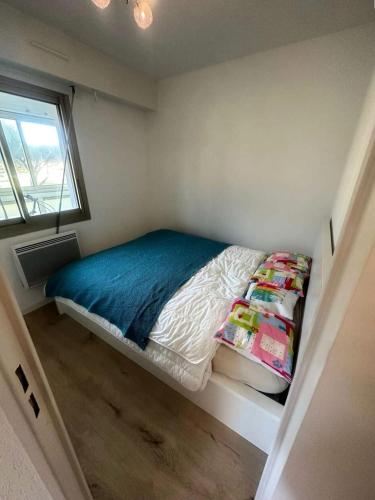 - un petit lit dans une petite chambre avec fenêtre dans l'établissement Résidence Marines D'aryana - Appartement refait à neuf 4 couchages proche plage dans résidence avec piscine MAE-8701, à Six-Fours-les-Plages