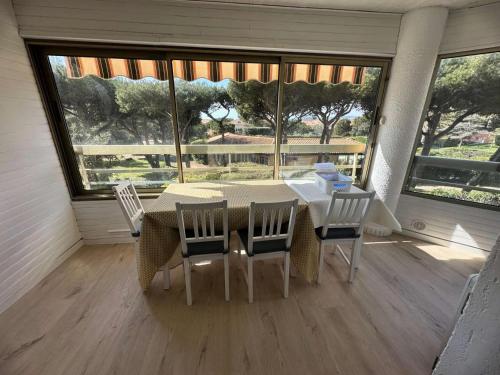 une salle à manger avec une table et quatre chaises dans l'établissement Résidence Marines D'aryana - Appartement refait à neuf 4 couchages proche plage dans résidence avec piscine MAE-8701, à Six-Fours-les-Plages
