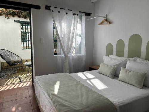 a bedroom with a large bed and a window at Casa Ande Hotel boutique in Villa de Leyva