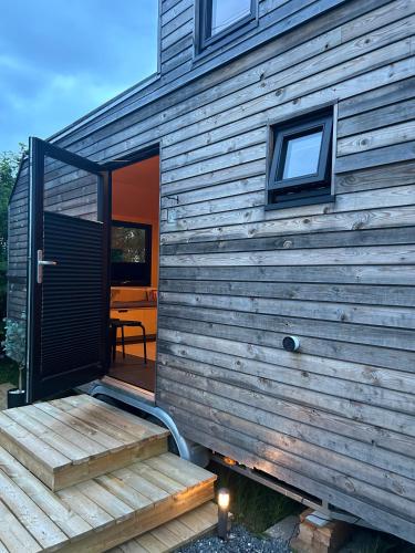 una casa di legno con una porta e un portico di legno di Modern Tiny House a Nes