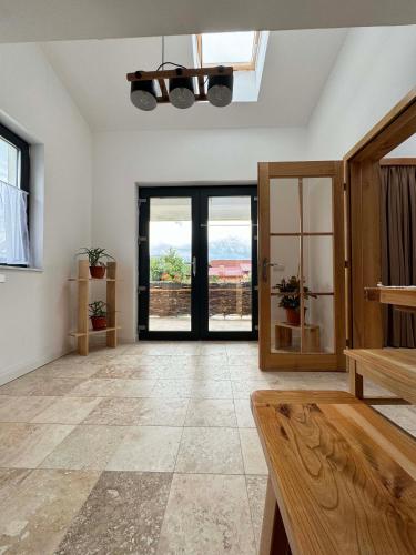 a large room with doors and windows with a view at Casuta Mosului in Ocna Şugatag