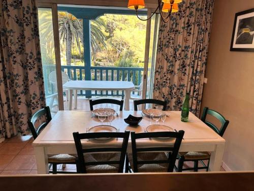 - une table avec des chaises et une table avec des verres à vin dans l'établissement Résidence Rivages - Appartement 2 chambres dans le domaine de la Coudoulière MAE-6121, à Six-Fours-les-Plages