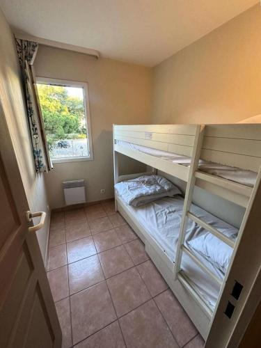 une chambre avec deux lits superposés et une fenêtre dans l'établissement Résidence Rivages - Appartement 2 chambres dans le domaine de la Coudoulière MAE-6121, à Six-Fours-les-Plages