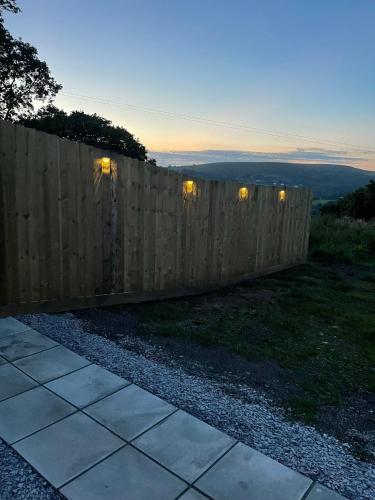 a fence in a yard with lights on it at Three bed static caravan with fantastic views and hottub in Swansea