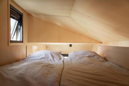 Posto letto in una piccola camera con finestra di Modern Tiny House a Nes