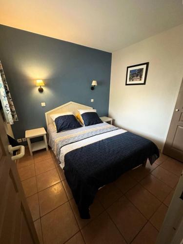 une chambre avec un lit et un mur bleu dans l'établissement Résidence Rivages - Cocktail des îles, joli T2 climatisé avec vue sur piscine et mer dans le domaine de la Coudoulière MAE-0521, à Six-Fours-les-Plages