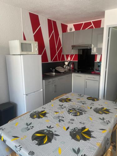 une cuisine avec une table avec un motif de papillon dessus dans l'établissement Studio cabine 4 pers, plage du Grazel, à Gruissan