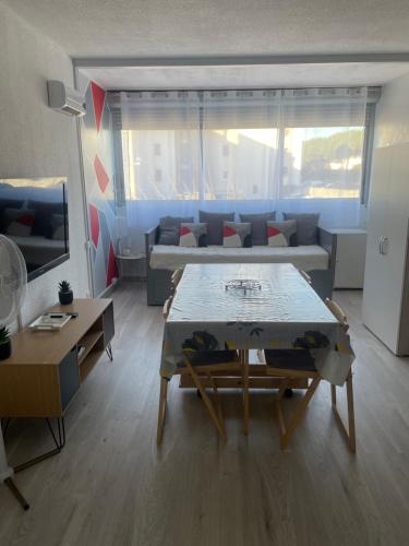 un salon avec un canapé et une table dans l'établissement Studio cabine 4 pers, plage du Grazel, à Gruissan