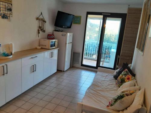 - une cuisine avec un canapé au milieu d'une pièce dans l'établissement Résidence Grand Large - Joli T2 dans le domaine de la Coudoulière avec piscine et tennis MAE-9701, à Six-Fours-les-Plages