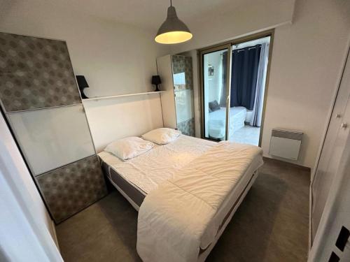 une petite chambre avec un lit et un miroir dans l'établissement Résidence Alisier - T2 dans le domaine de la Coudoulière proche de la mer MAE-1191, à Six-Fours-les-Plages