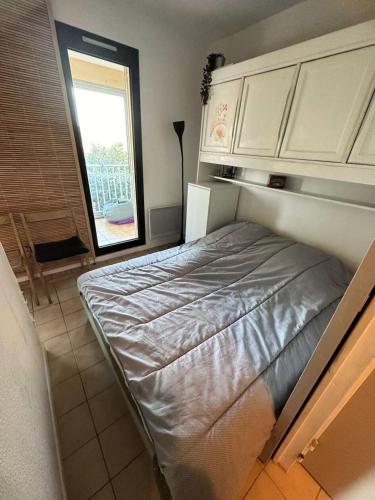 un lit dans une chambre avec une fenêtre dans l'établissement Résidence Grand Large - Joli T2 dans le domaine de la Coudoulière avec piscine et tennis MAE-9701, à Six-Fours-les-Plages