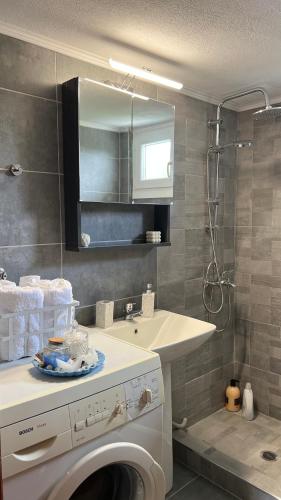 a bathroom with a washing machine and a sink at Sea and Sand House in Orfánion