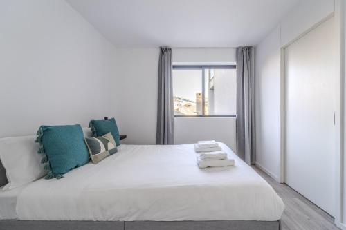 Un dormitorio blanco con una cama grande y una ventana. en The Locomotive Flat by House and People, en Braga