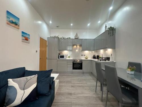 a kitchen and living room with a couch and a table at On the Beach Retreat in Bournemouth