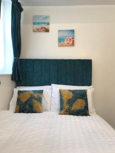a bedroom with a white bed with a green headboard at On the Beach Retreat in Bournemouth