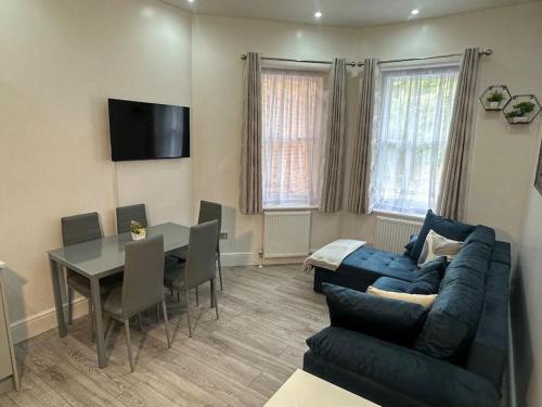 a living room with a blue couch and a table at On the Beach Retreat in Bournemouth
