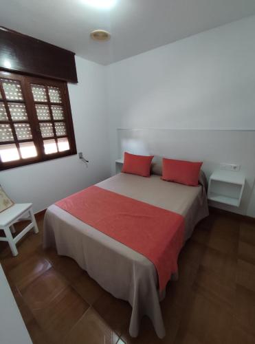 a bedroom with a large bed with red pillows at Apartamentos Faxilda in Sanxenxo