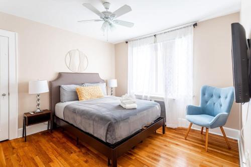 a bedroom with a bed and a blue chair at The B&W Haven 5BR Home with yard theater in Bridgeport