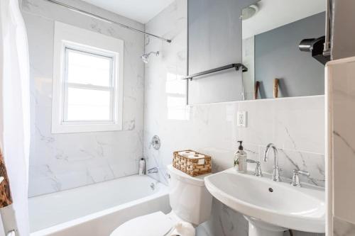 a white bathroom with a sink and a toilet at The B&W Haven 5BR Home with yard theater in Bridgeport