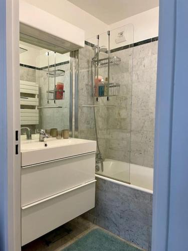 une salle de bain avec une baignoire, un lavabo et une douche dans l'établissement Modern Bright Lovely Apartment, à Levallois-Perret