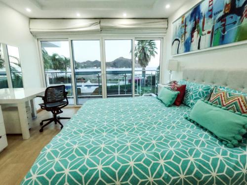 a bedroom with a large bed and a desk and windows at Casa Serena in San Juan del Sur