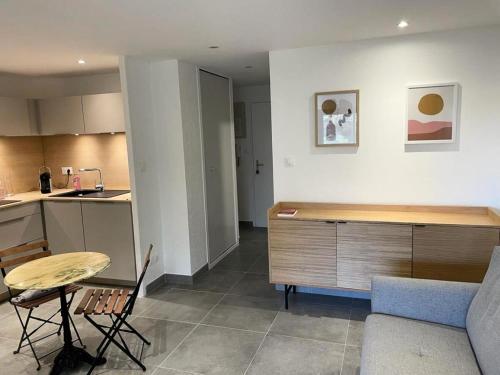 Il dispose d'une cuisine et d'un salon avec une table et un canapé. dans l'établissement Résidence Alisier - T3 avec petite vue mer dans le domaine de la coudoulière MAE-8301, à Six-Fours-les-Plages