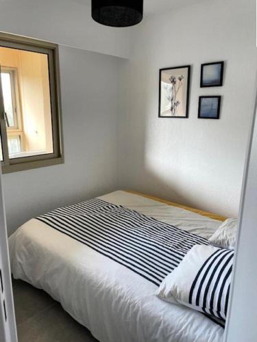 - un lit dans une chambre avec un miroir et une fenêtre dans l'établissement Résidence Alisier - T3 avec petite vue mer dans le domaine de la coudoulière MAE-8301, à Six-Fours-les-Plages