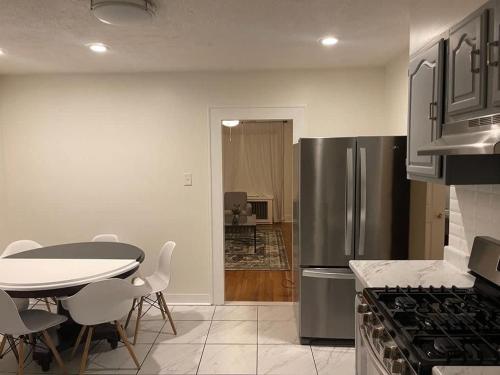 a kitchen with a table and a stainless steel refrigerator at The B&W Haven 5BR Home with yard theater in Bridgeport