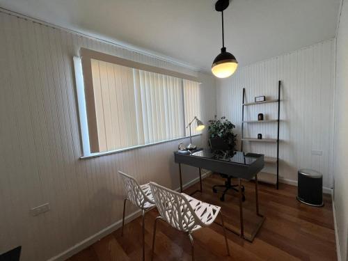a room with a desk and chairs and a window at The B&W Haven 5BR Home with yard theater in Bridgeport