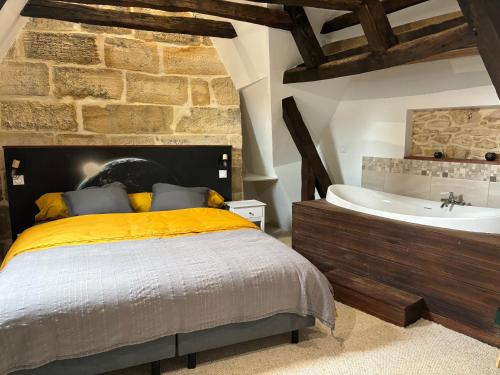 une chambre avec un lit et une baignoire dans l'établissement La cabane suspendue de Sarlat, à Sarlat-la-Canéda