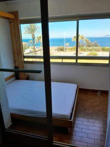 Ce lit se trouve dans un dortoir offrant une vue sur l'océan. dans l'établissement Résidence Marines D'aryana - Appartement 5 couchages proche plage dans résidence avec piscine MAE-3651, à Six-Fours-les-Plages