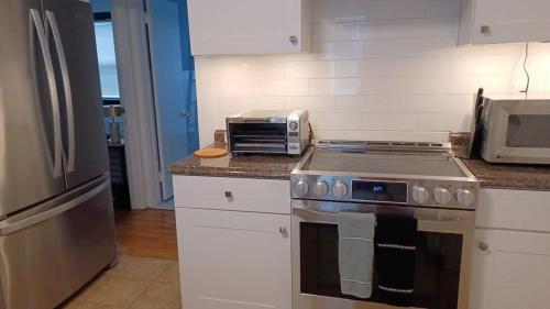 a kitchen with a stove and a microwave at The B&W Haven 5BR Home with yard theater in Bridgeport