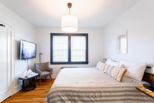 a bedroom with a large bed and a chair at The B&W Haven 5BR Home with yard theater in Bridgeport