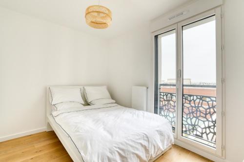une chambre blanche avec un lit et une grande fenêtre dans l'établissement C est Votre Maison, à Rueil-Malmaison