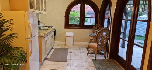 a kitchen with a white refrigerator and a table at Sandpiper Beach Apartments in Palm-Eagle Beach