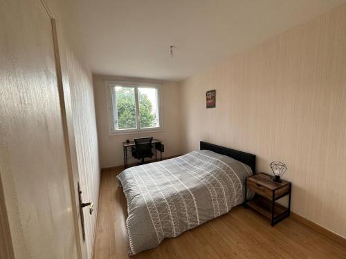 une chambre avec un lit et une fenêtre dans l'établissement appartement type 5 proche circuit des 24h du mans, au Mans