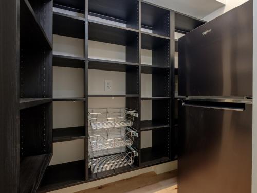 a walk in closet with black shelves and a refrigerator at The Retreat at Valley Bear Farms in Balsam Grove