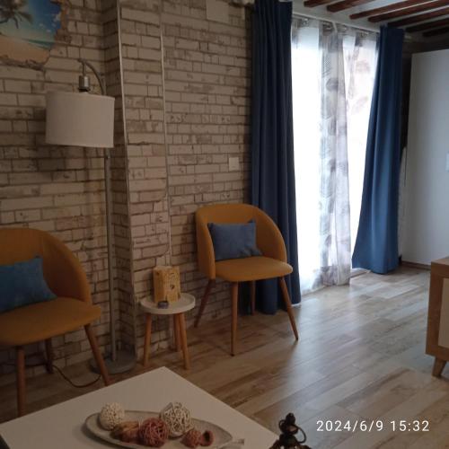 a living room with two chairs and a table at Apartamento Turístico El Empedrado de M&G in Colmenar de Oreja