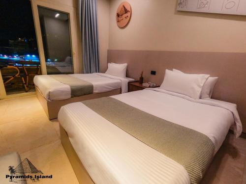 a hotel room with two beds and a window at Pyramids Island in Cairo